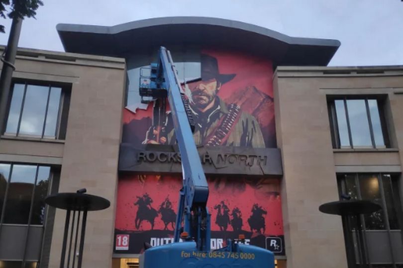 Рабочие снимают плакат RDR2 с фасада штаб-квартиры Rockstar North. Источник: Dexerto.com